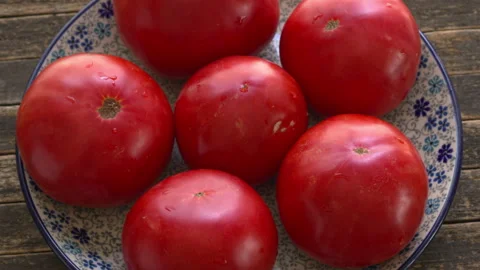 Brandywine heirloom tomatoes on a ceramic plate. Video stock 345086773