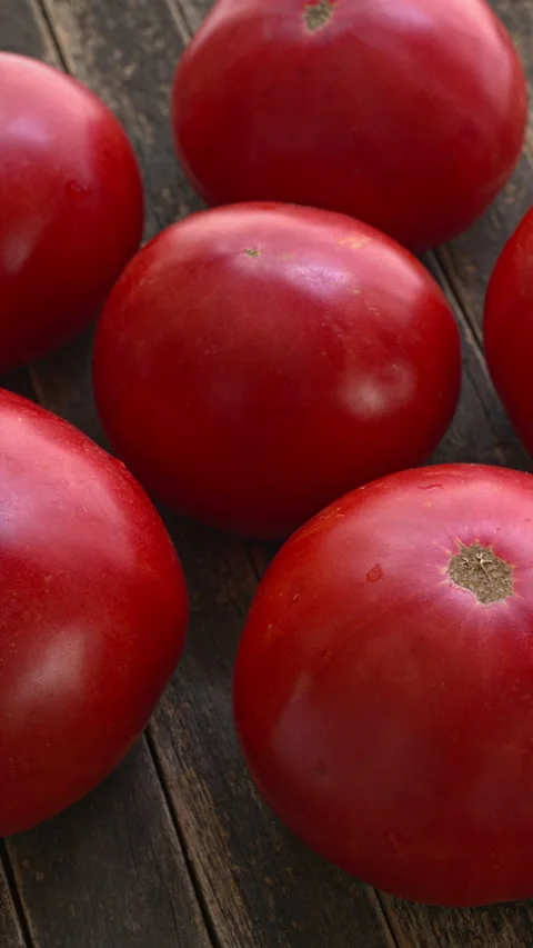Brandywine heirloom tomatoes rotating on dark rustic wood, vertical video Stock-Footage 342848290