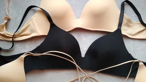 Bras in beige and black close-up on a gray background Stock Footage 147939497