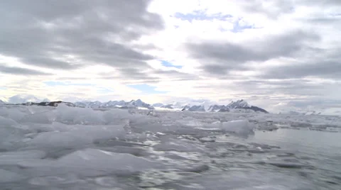 Brash ice at water level, sunlit mountains, Antarctica Stock Footage 34313386