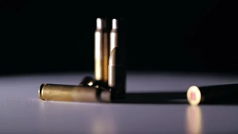 Brass Bullet Rotates With Empty Shells On Dark Background Cinematic Light Stock Footage 324026165