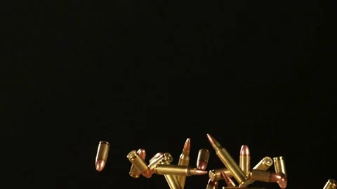 Brass bullets falling and tumbling through a black void in slow motion Stock Footage 326624833