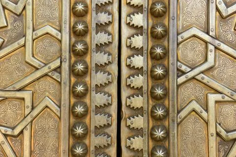 Brass doors adorned with Moroccan patterns, metal filigree, and intricate r.. Foto stock