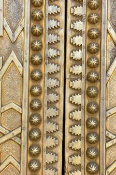 Brass doors adorned with Moroccan patterns, metal filigree, and intricate r.. Фото