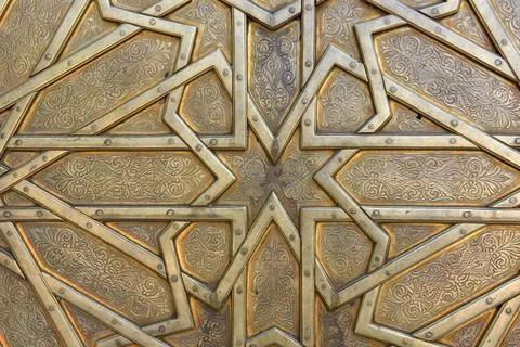 Brass doors adorned with Moroccan patterns, metal filigree, and intricate r.. Stock Photos