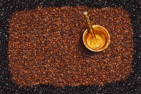 Brass mortar centered on roasted coffee beans Foto stock