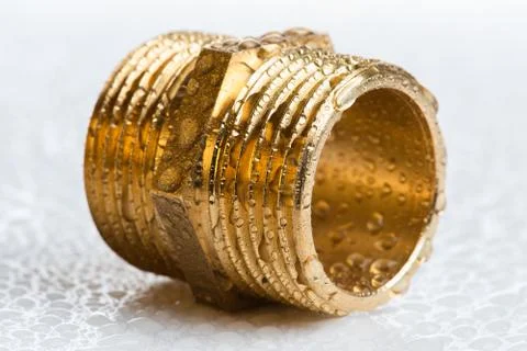Brass pipe fitting on wet workshop table Stock-Fotos