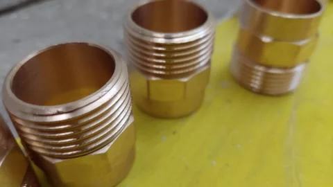 Brass threaded pipe nipples fittings on yellow background Vídeos de archivo 336901086