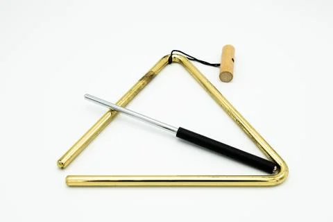 A brass triangle lying on a white underground Stock Photos