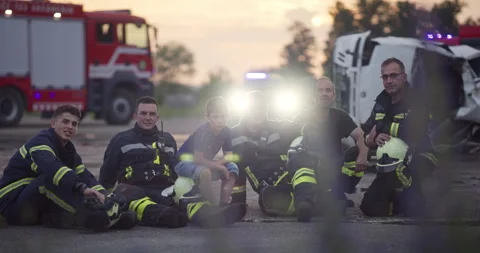 Brave Firefighters Team Walking to the Camera. In Background Paramedics and Stock Footage 247795313
