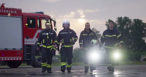 Brave Firefighters Team Walking to the Camera. In Background Paramedics and Video stock 253759268