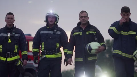 Brave Firefighters Team Walking to the Camera. In Background Paramedics and Stock Footage 305540995