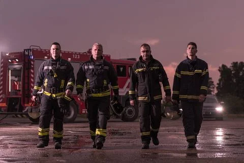 Brave Firefighters Team Walking to the Camera. In Background Paramedics an... Stock Photos