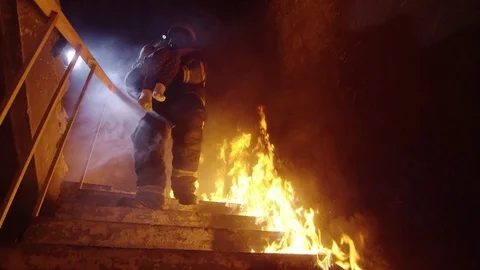 Brave Fireman Descends Burning Stairs with Saved Little Girl in His Hands.  Stock Footage