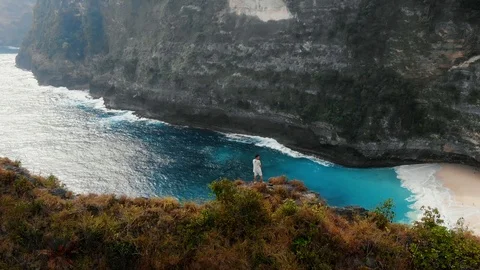 A brave guy stands on the edge of a cliff in Bali 1st part Stock Footage 126142833