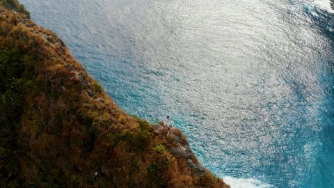 A brave guy stands on the edge of a cliff in Bali 3rd part Stock Footage