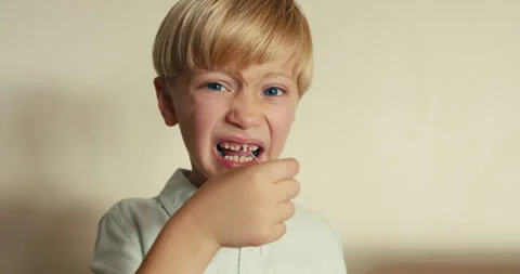Brave little boy pulling out his first milk tooth Stock-Footage 346982894