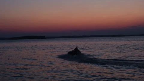 A brave man floats on an inflatable motorized boat along the river at sunset. Видео 249229224