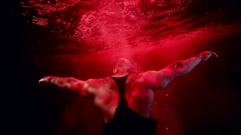 Brawny man is sinking in red deepness, dramatic underwater shot, motionless male Stock-Footage 169859084