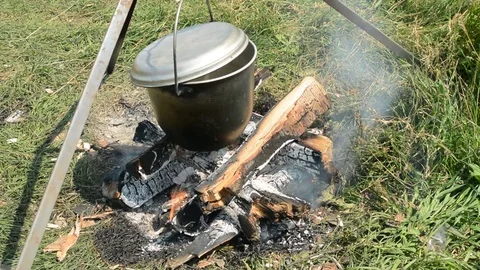 Brazier marching with fire during a halt on the nature. Tourist food in the wood Stock Footage