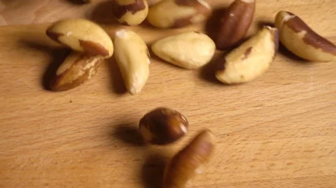 Brazil nuts spill onto table in slow motion Stock Footage 61691420