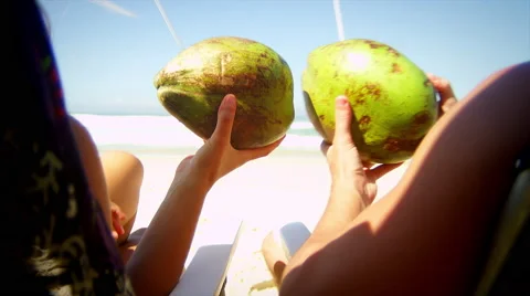 Brazilian couple sit on a beach drinking fresh Coconut water 库存影片 49835053