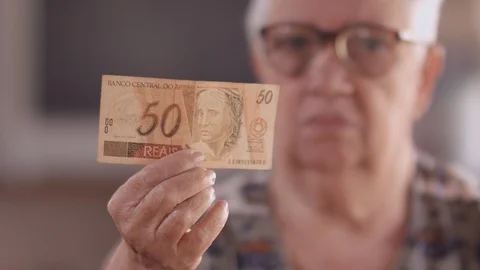 A Brazilian elderly lady shows a note of 50 reais Stockbeeldmateriaal 93909466