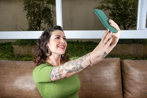 Brazilian tattooed doing using both hands to make selfie. Stock Photos