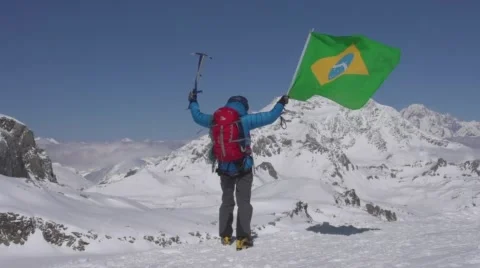 Brazillian mountaineer stands on summits waving Brazilian Flag Vídeo Stock 59162252