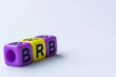 BRB text representing Be Right Back on small square toy on white background.. Stock Photos