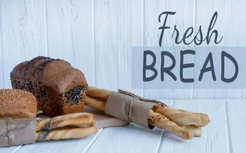 Bread and bread sticks on a light wooden background. Homemade cakes and groce Stock Photos