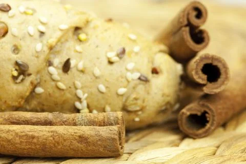Bread and cinnamon sticks on a wicker mat Stock Photos