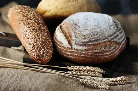 Bread and grain ears on burlap Foto stock