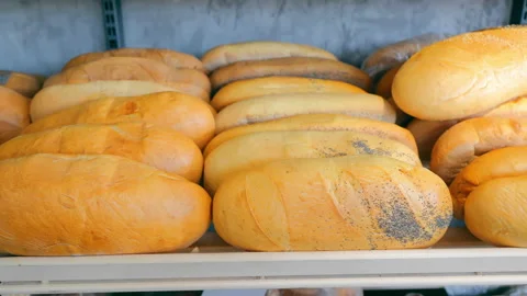 Bread and a long loaf lie on the store counter. Freshly baked bread on the Stock Footage 238913300