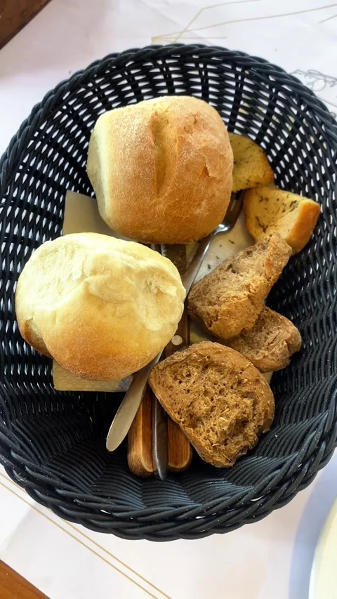 Bread and rolls in a basket. Knife and fork. Vertical video Stock Footage 286115025