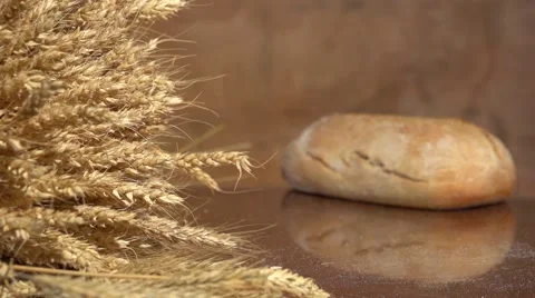 Bread and wheat ears on the table. Slow motion 240 fps. Vídeo Stock 55284059