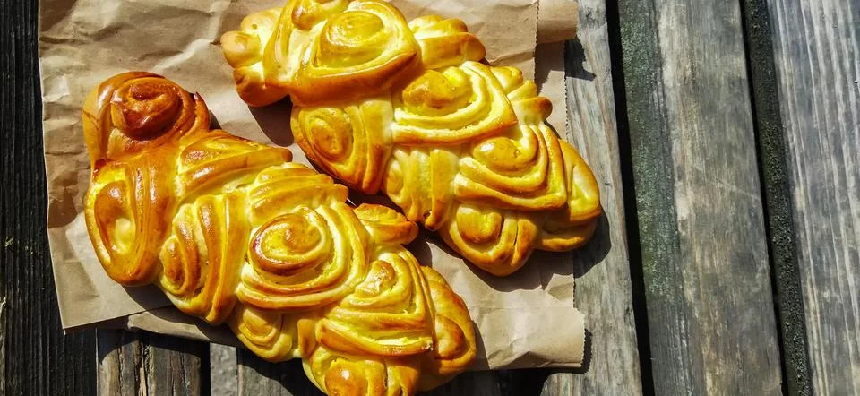 Bread art, small buns with openwork modeling on top lie on the table Stock Photos