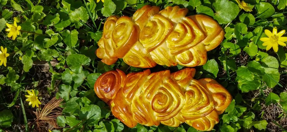 Bread art, small buns with openwork modeling on top lie on the green grass Stockfoto's