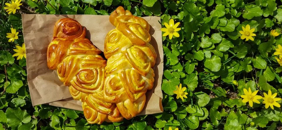 Bread art, small buns with openwork modeling on top lie on the green grass Stock Photos