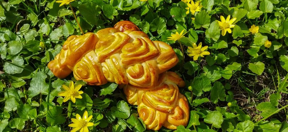 Bread art, small buns with openwork modeling on top lie on the green grass Stock Photos