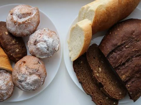 Bread assortment on white plates top view Stock Photos