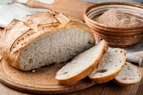 Bread. Baked bread. Craft bakery. Sliced bread on a wooden background. Food b Stock Photos