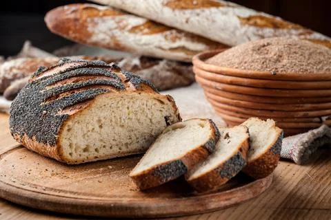 Bread. Baked bread. Craft bakery. Sliced bread on a wooden background. Food b Stock Photos