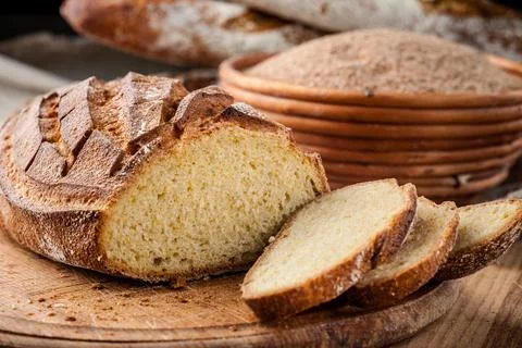 Bread. Baked bread. Craft bakery. Sliced bread on a wooden background. Food b Stock Photos
