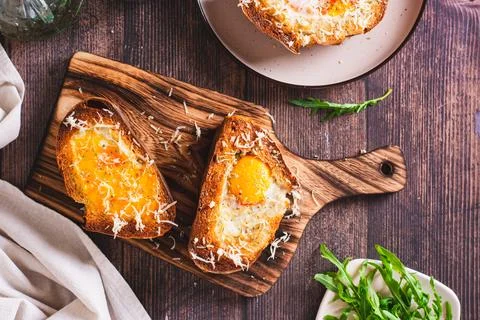 Bread baked with egg and cheese on a cutting board top view Stock Photos