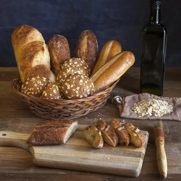 Bread in basket and on a cutting board. Stock Photos