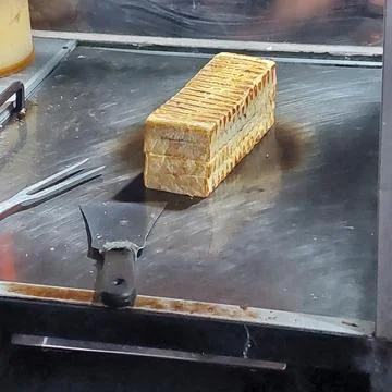 Bread that is being baked and smeared with cheese and chocolate Stock Photos