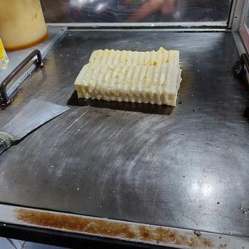 Bread that is being baked and smeared with cheese and chocolate Stock Photos