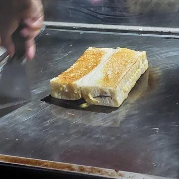 Bread that is being baked and smeared with cheese and chocolate Stock Photos