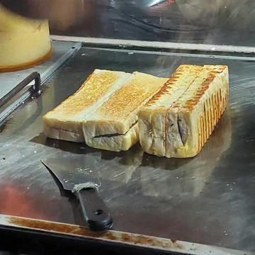 Bread that is being baked and smeared with cheese and chocolate Stock Photos